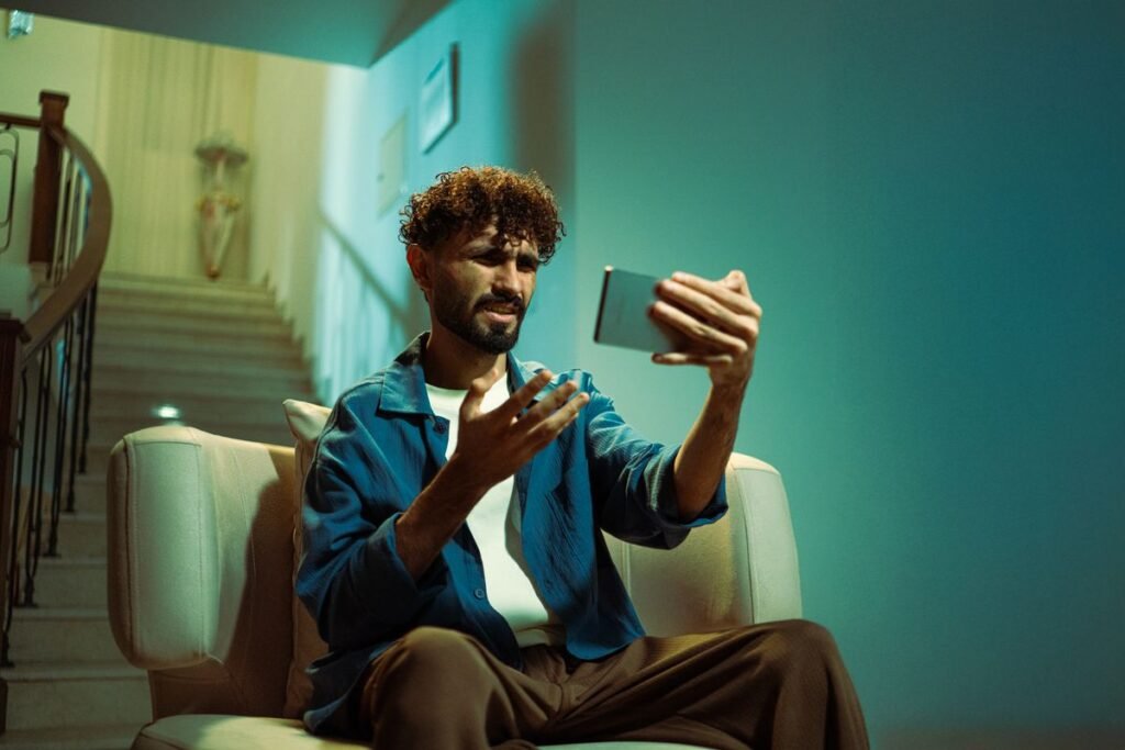 Confused man looking at his smartphone indoors